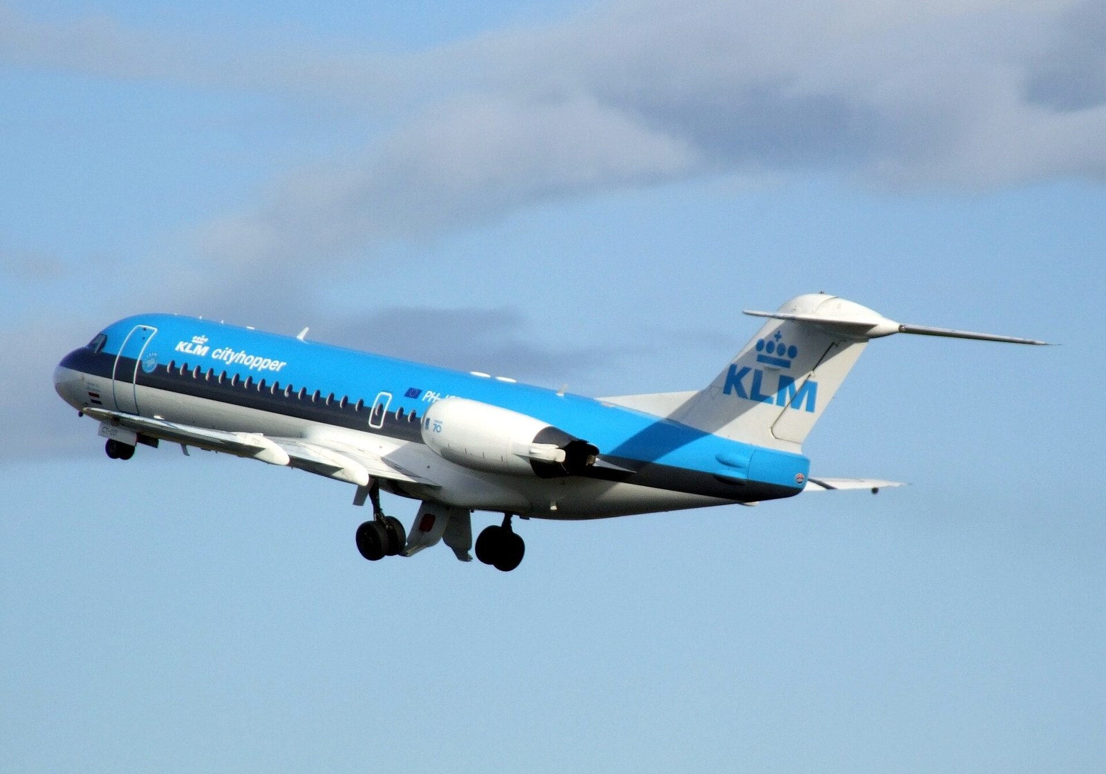 Een Fokker 70 van KLM Cityhopper bij de start op Schiphol