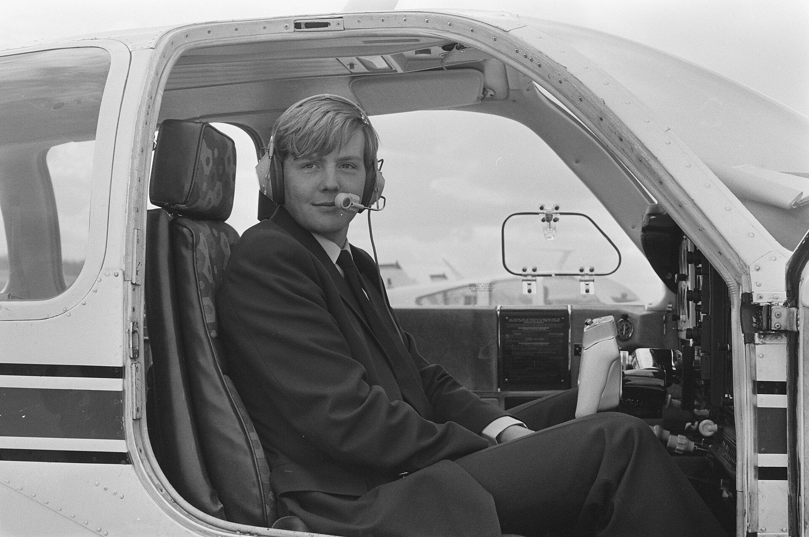 Prins Willem-Alexander met headset in de cockpit van een Beechcraft Bonanza in 1987