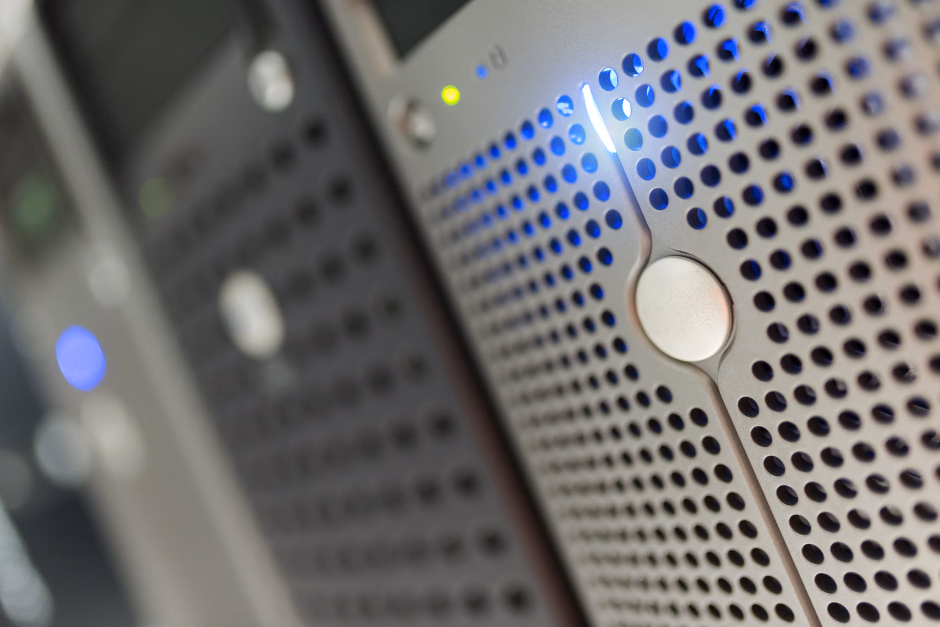 Close-up van een geperforeerd serverfront met blauw en groen statuslicht in een datacenter