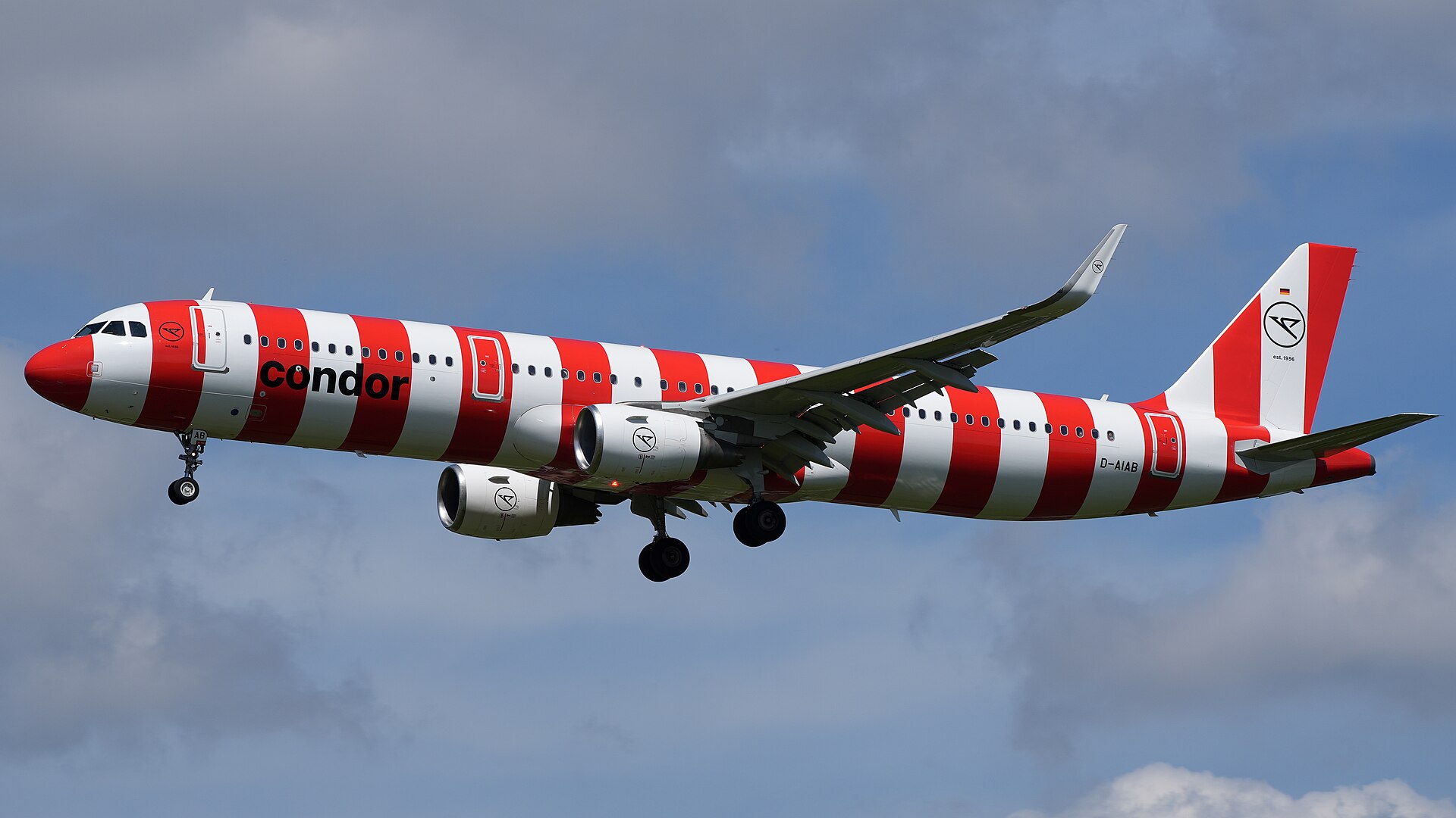Een Airbus A321 van Condor in rood-witte strepen nadert met uitgeklapt landingsgestel