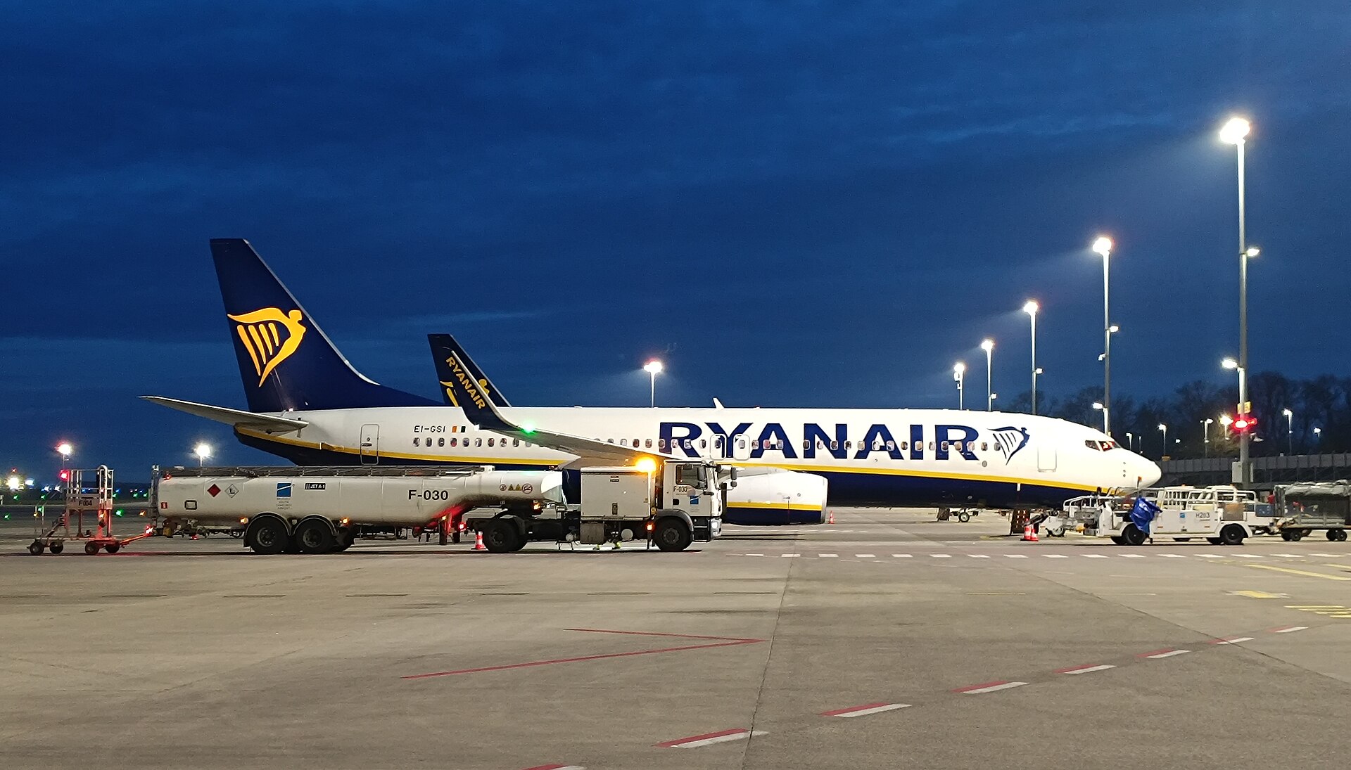 Een Boeing 737 van Ryanair staat bij schemering op het platform met een tankwagen ervoor